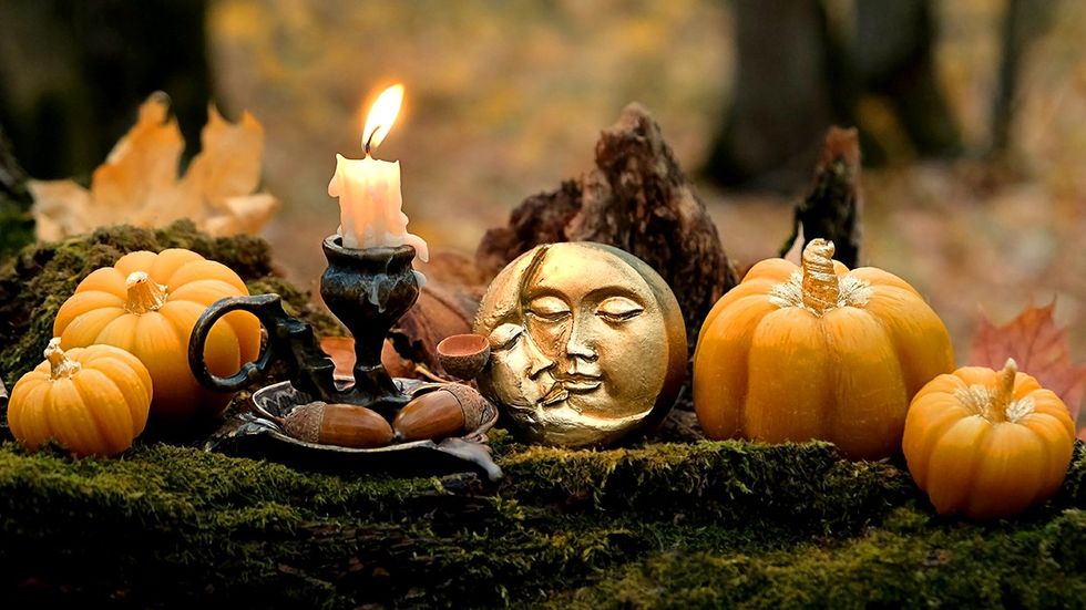 burning candle moon amulet decorative pumpkins in forest autumn nature background Samhain Halloween Witchcraft esoteric spiritual ceremony magic ritual witch aesthetic autumnal equinox