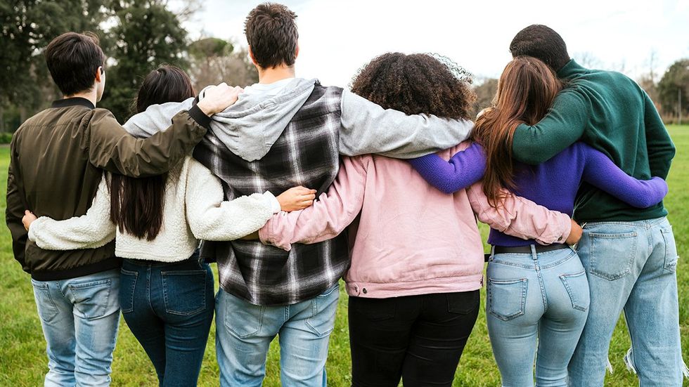 diverse teenage friend group hugging support