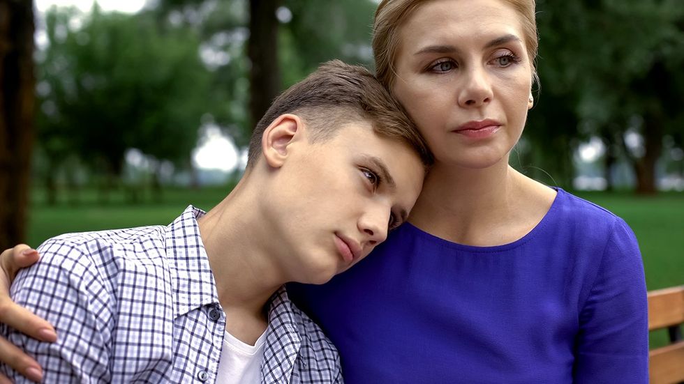 sad transgender teenager leaning on caring parent